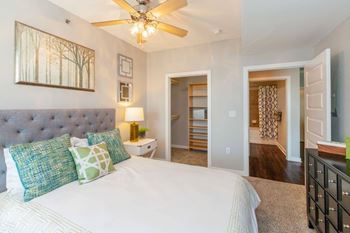 A bedroom with a large bed and a ceiling fan